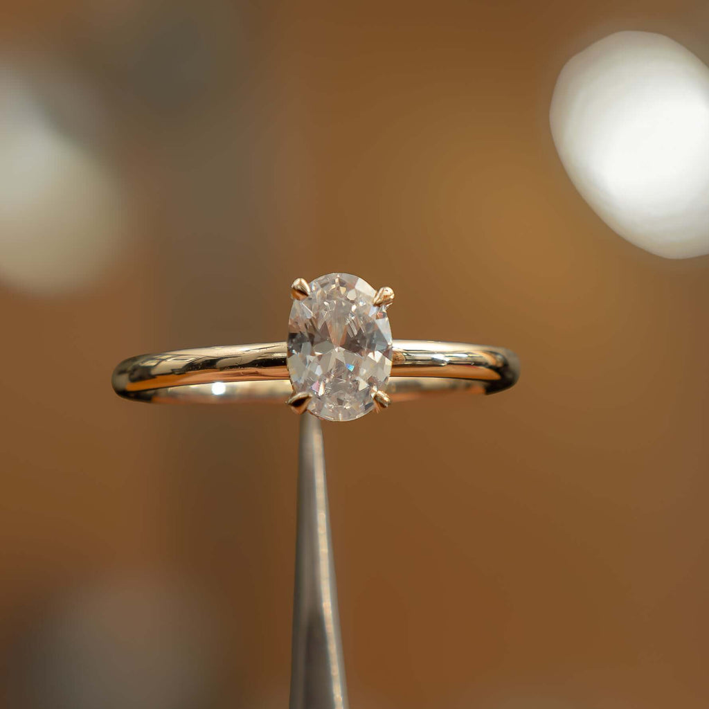 image of luxury oval yellow gold hidden halo lab grown diamond engagement ring