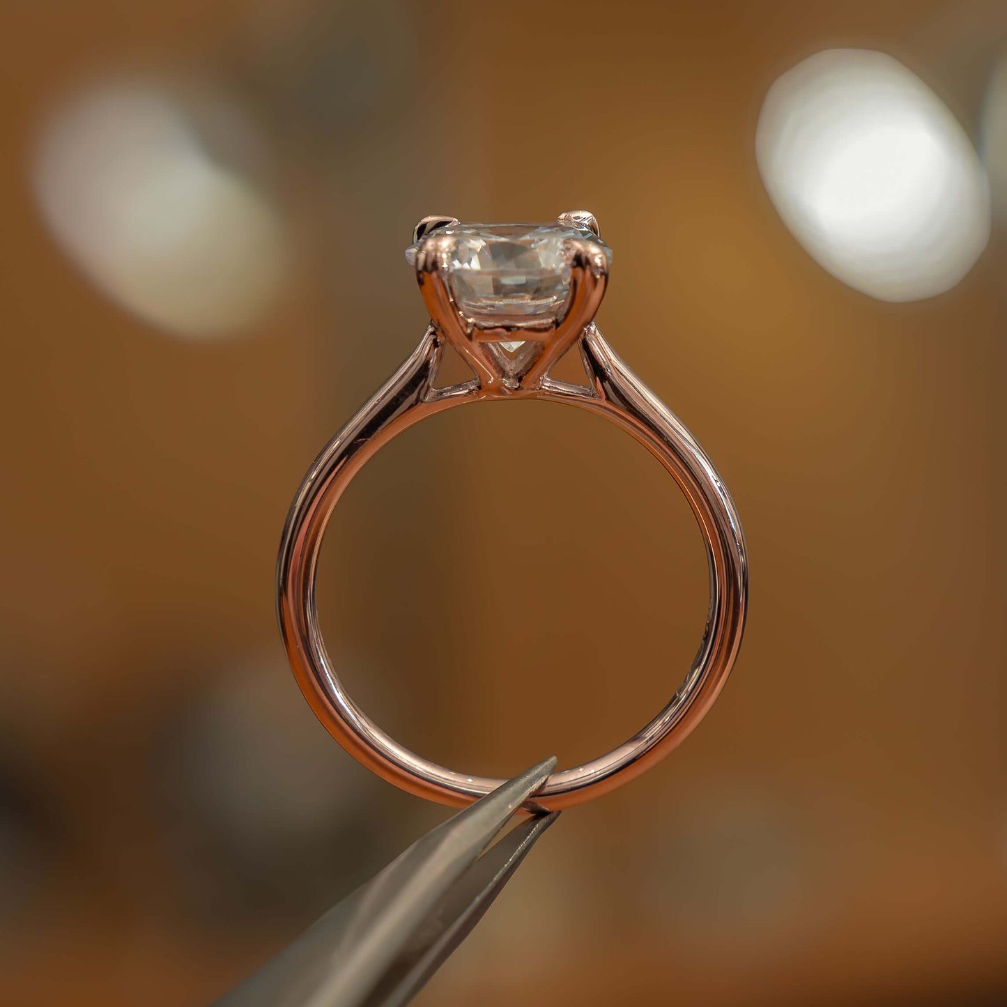 studio side image of luxury round rose gold solitaire lab grown diamond engagement ring