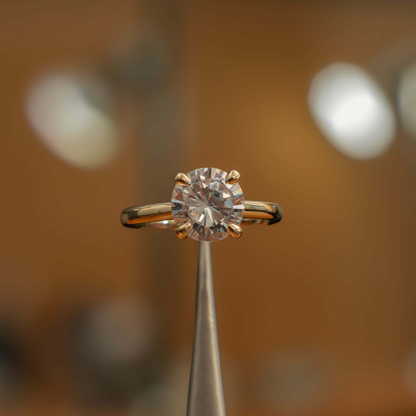 frontal view luxury yellow gold solitaire round lab grown diamond engagement ring in studio