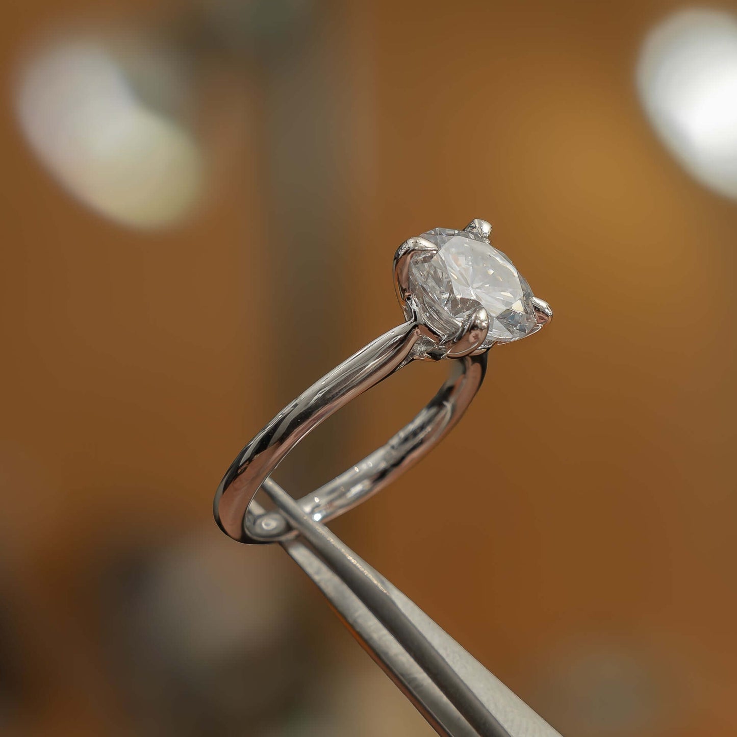 side angle luxury platinum solitaire round lab grown diamond engagement ring in studio