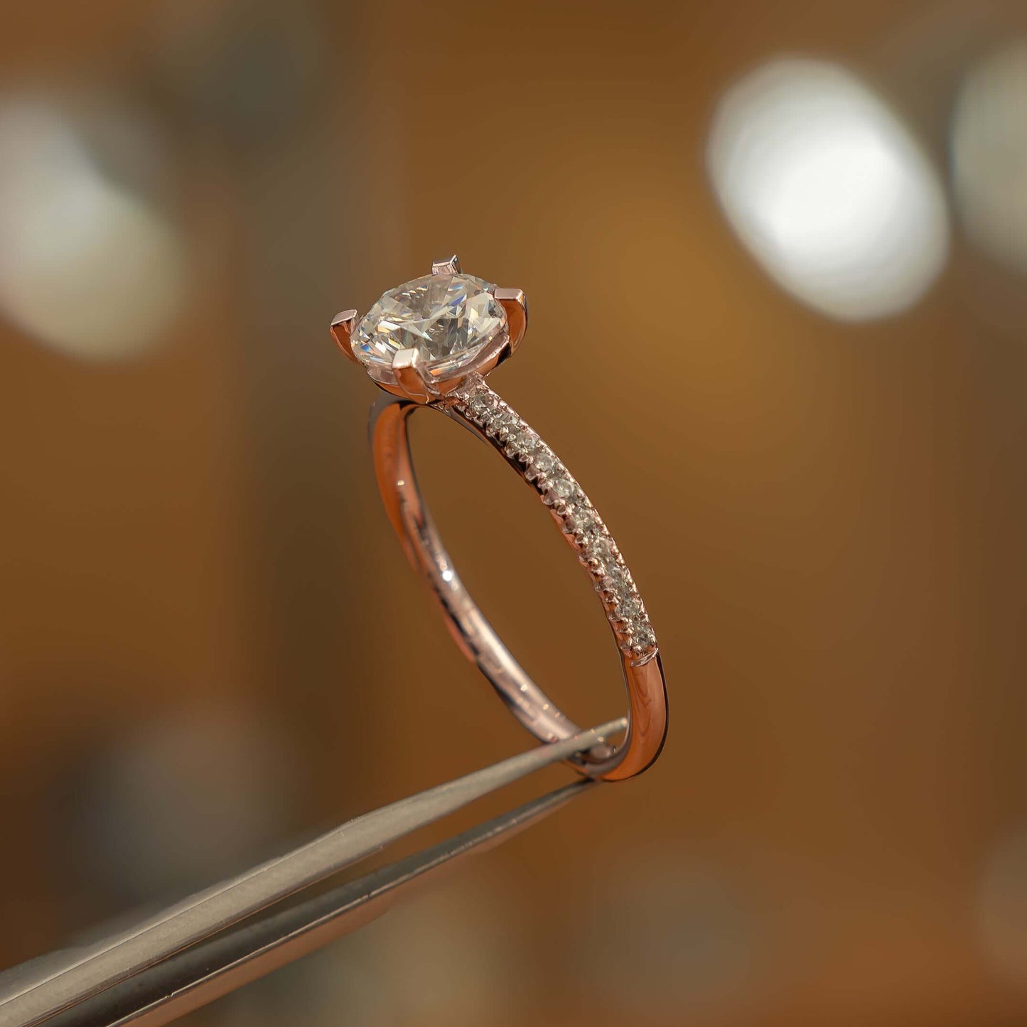 side angle luxury round rose gold diamond set shoulders lab grown diamond engagement ring in studio