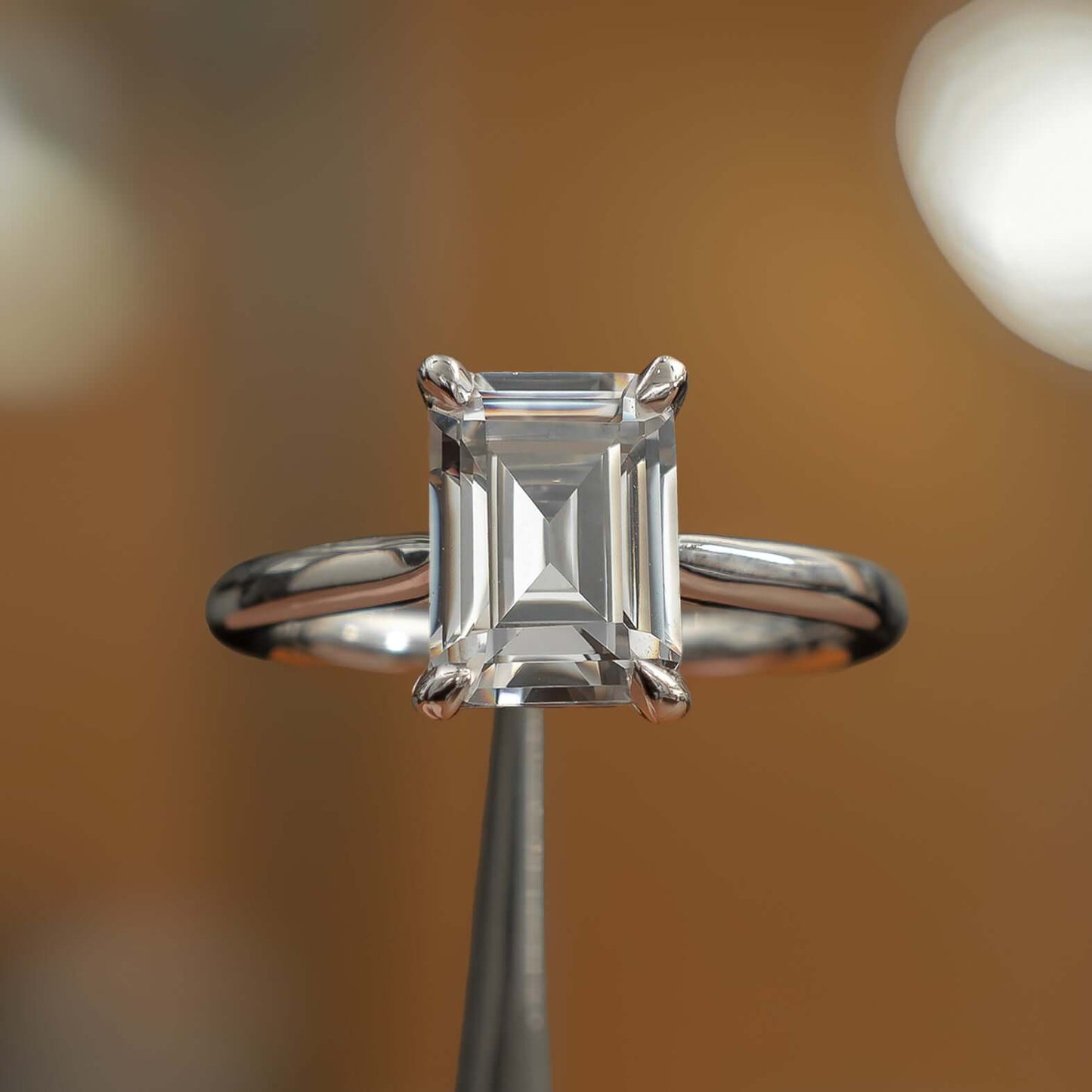 frontal view luxury emerald platinum solitaire lab grown diamond engagement ring in studio
