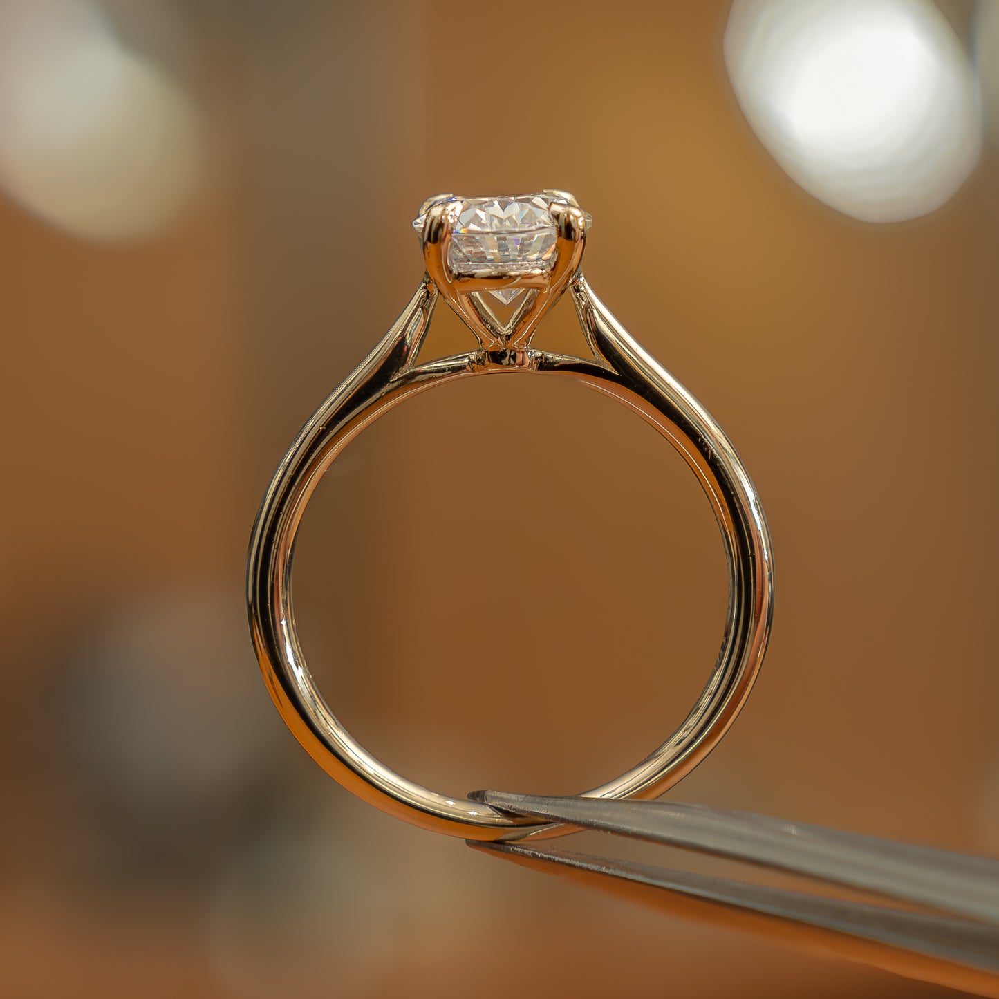 side image of luxury oval yellow gold solitaire lab grown diamond engagement ring in studio