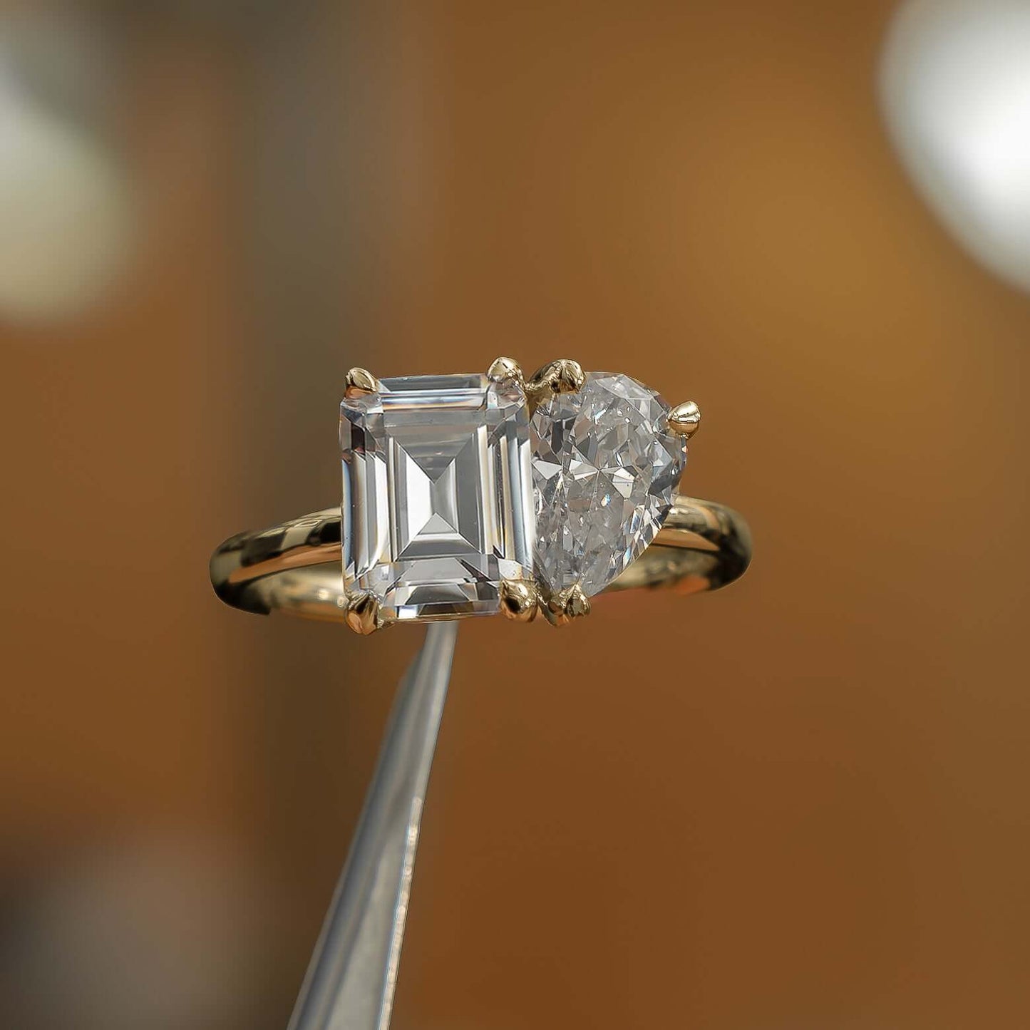 luxury emerald and pear yellow gold lab grown diamond pair engagement ring in studio